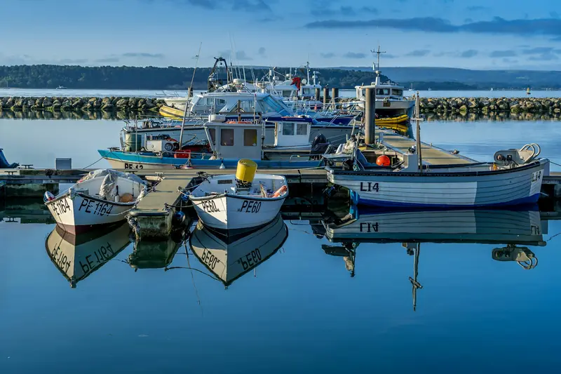 Small boats moored in a harbour under a blue sky
